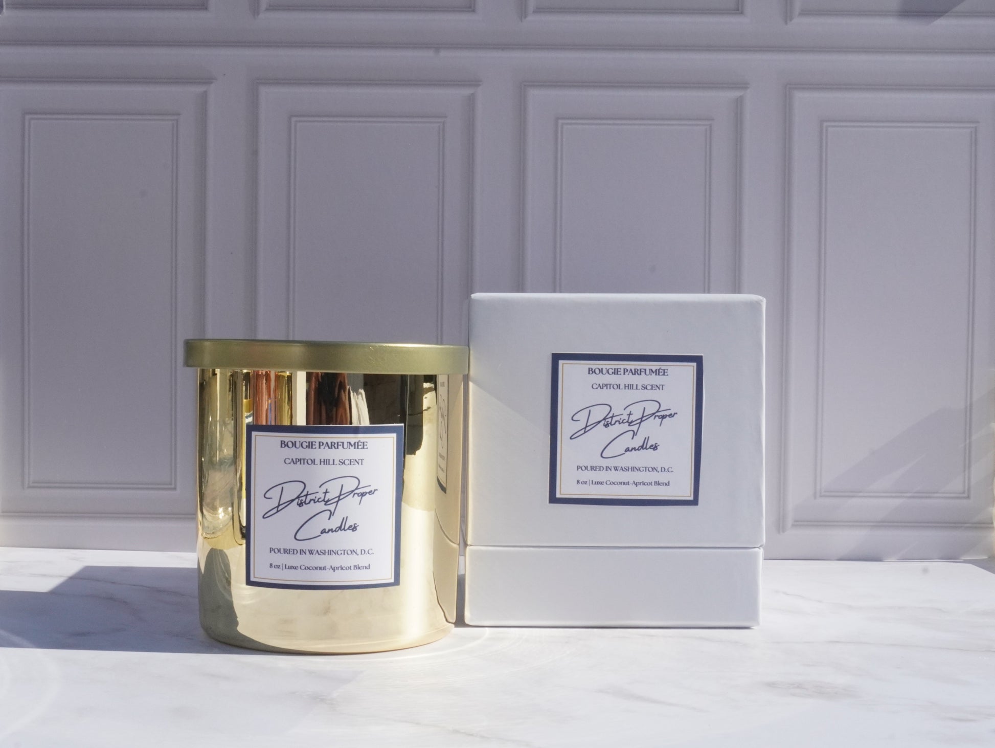 Gold candle with luxury packaging. Capitol Hill premium candle in coconut apricot wax. Smells like rich amber.