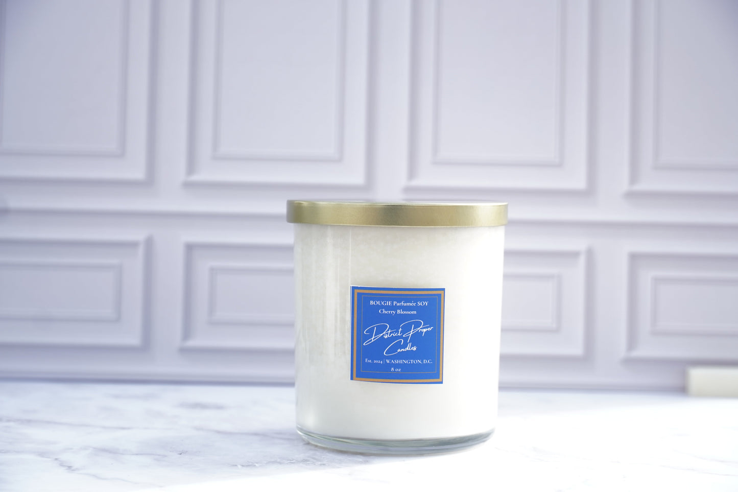 White candle with a gold lid. Cherry blossom candle in soy wax. Smells like vanilla, lavender and a hint of cherry.