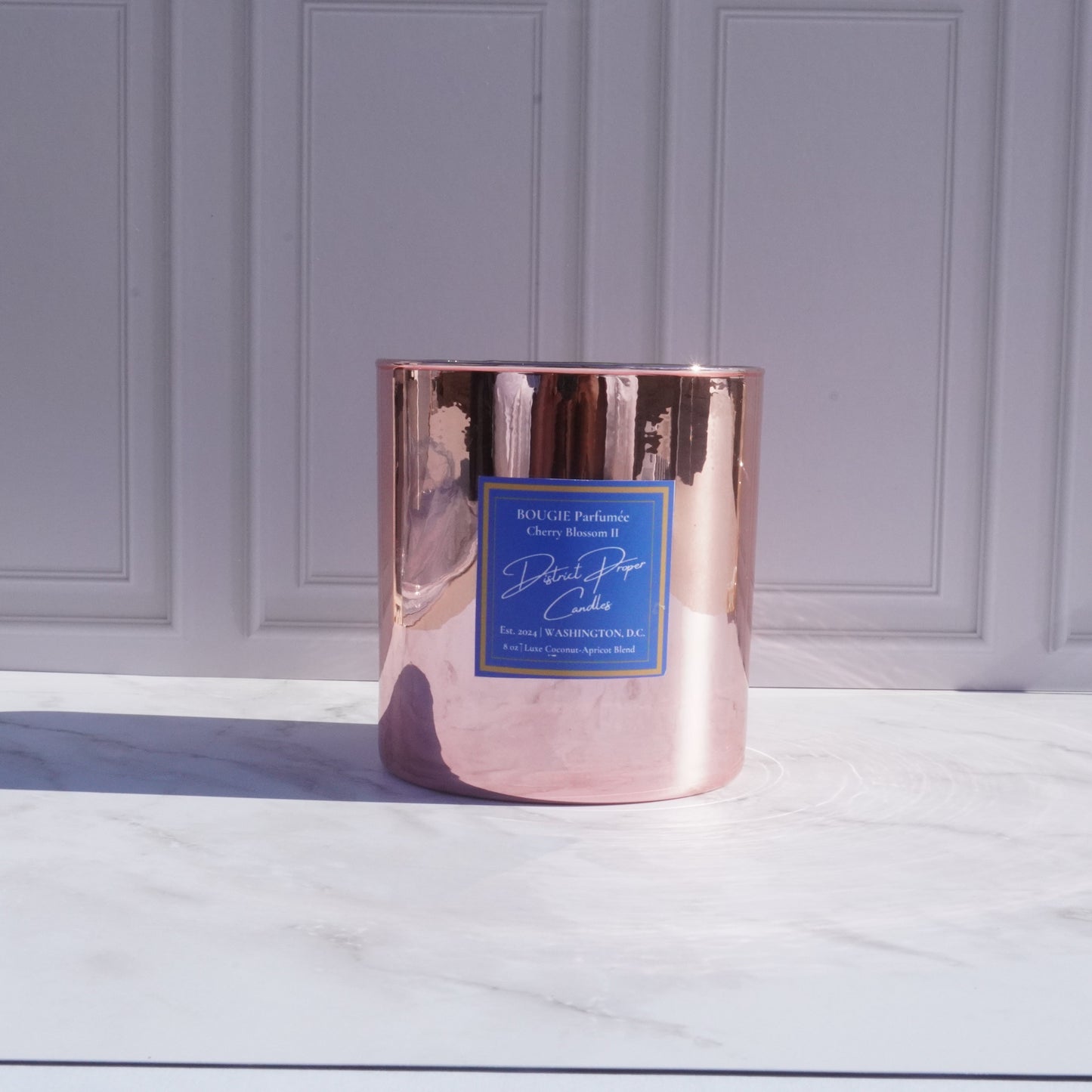 Gold candle with luxury packaging. Capitol Hill premium candle in coconut apricot wax. Smells like rich amber.