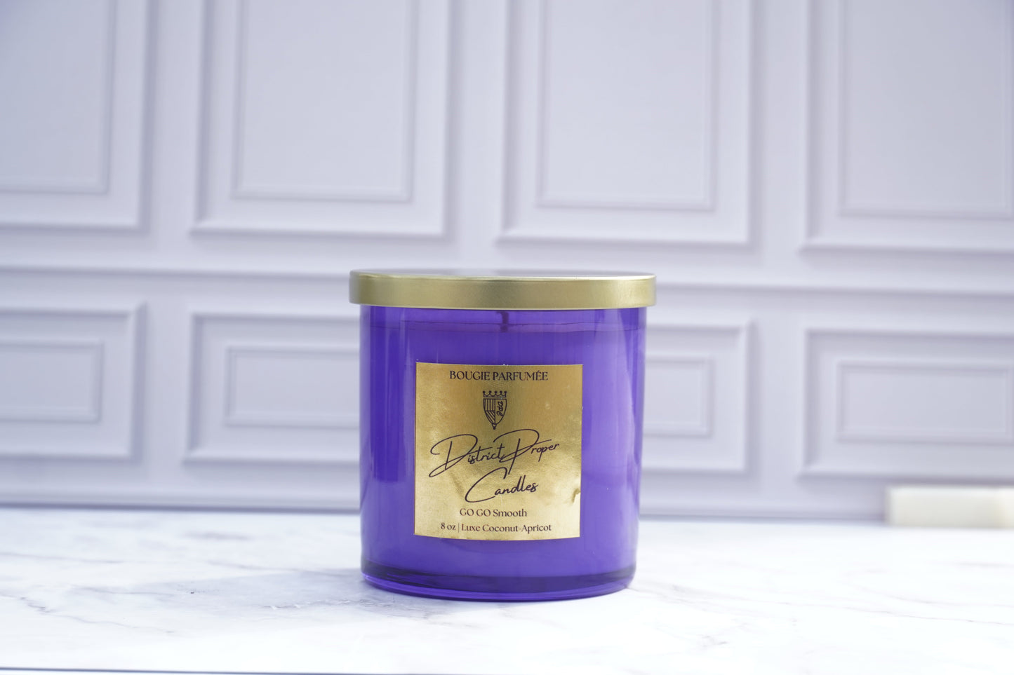 Purple candle with gold lid. GoGo Smooth luxury candle handpoured in a luxurious coconut apricot wax. Candle smells like driftwood, clean rouge, hint of spice.