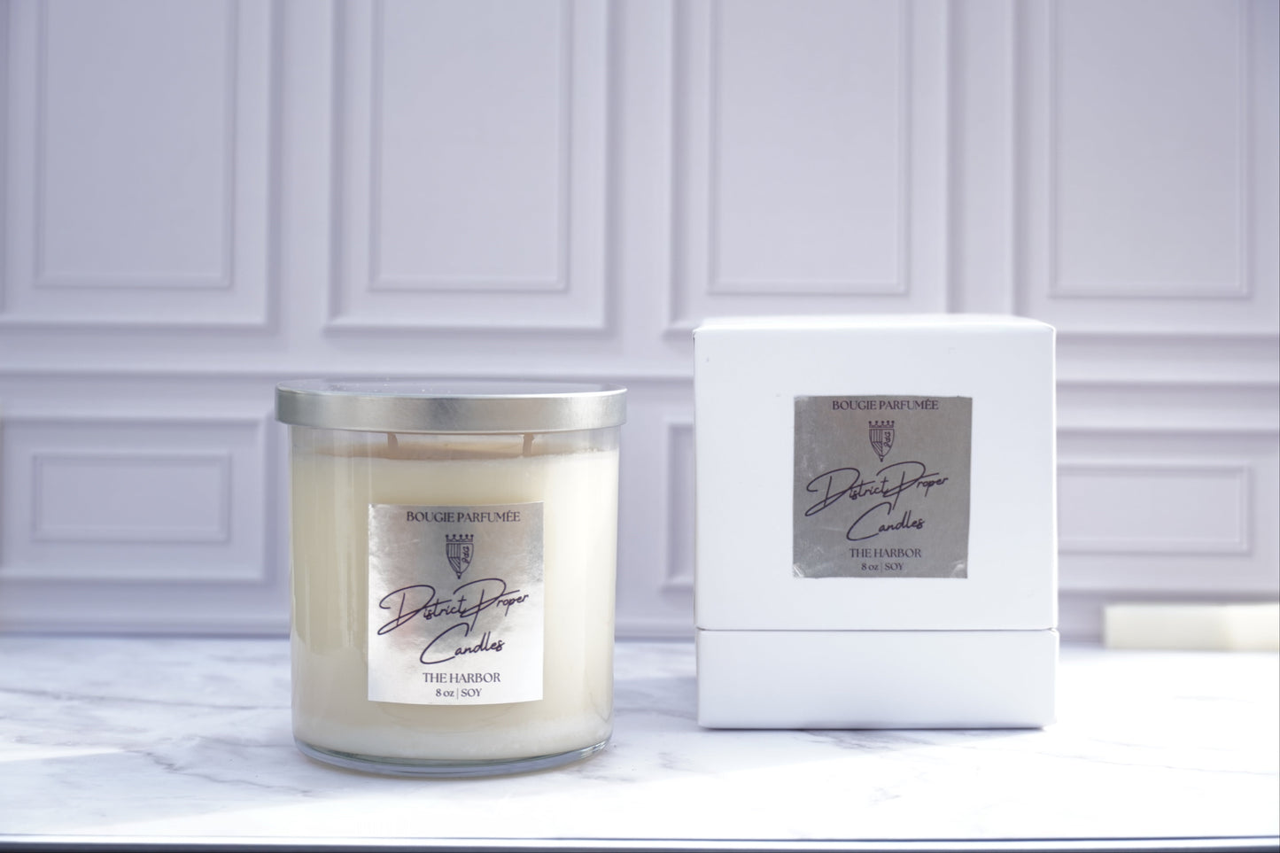 Candle and its packaging on white marble surface. Harbor candle handpoured in soy wax. Smells like citrus, ocean breeze and clean fragrance.